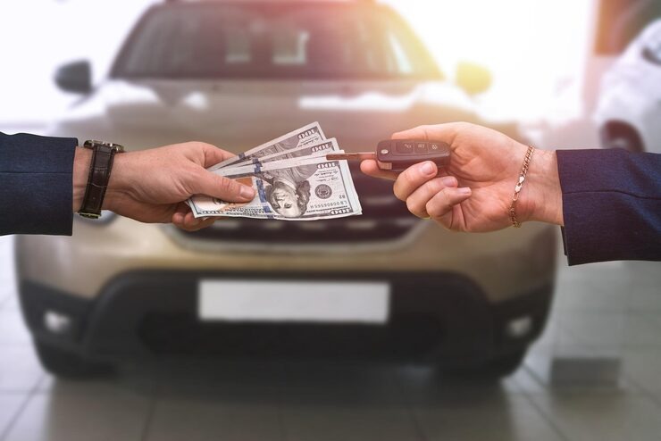 Cash for Cars West Coast customer receiving instant cash while handing over car keys after selling a used vehicle
